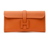 an orange leather clutch bag with a metal clasp