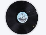 an old vinyl record sitting on top of a white surface