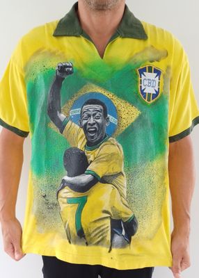 un homme portant un t-shirt jaune sur lequel figure l'image d'un footballeur