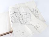 an open book with drawings of a map and a bookmark on it