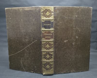 an old book sitting on top of a wooden table next to a gray wall