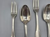 four silver spoons and a fork are lined up on a table
