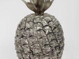a silver pineapple with a leaf on top of it