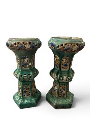 pair of green vases with floral designs on them against a white background