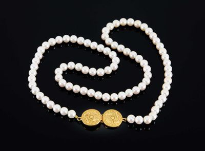 un collier de perles blanches avec un fermoir en or