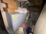 a metal cabinet in the middle of a room with boxes on it