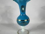 a blue vase that is sitting on a glass stand
