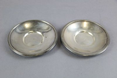 a pair of silver plated bowls with beading on each side