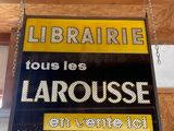 a sign hanging from the ceiling of a library