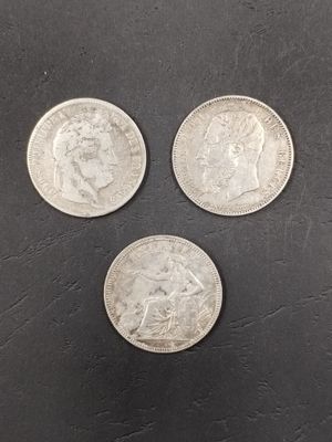 trois pièces d'argent britanniques sur un fond noir