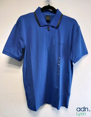 a blue polo shirt hanging on a wall next to a hanger