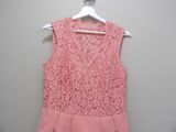 the pink dress is hanging on a hanger on the wall