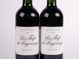 deux bouteilles de vin rouge posées l'une à côté de l'autre sur une surface blanche