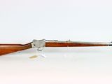 a rifle with a wooden barrel and a wooden handle on a white surface