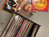 une boîte remplie de disques vinyles posée par terre