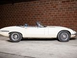 a white car parked in front of a brick wall