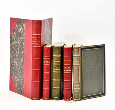 several old books are stacked on top of each other on a white surface