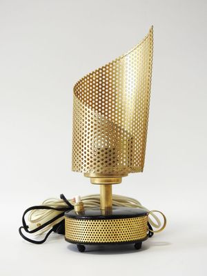 a gold lamp with a black base and a white cord