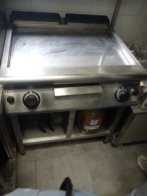 une personne se tient dans une cuisine équipée d'une cuisinière et d'un four