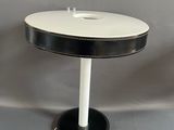 une photo d'une lampe de table en noir et blanc avec un pied blanc