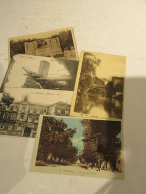 de nombreuses vieilles photos d'un bâtiment et d'arbres posées sur la table