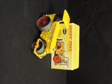 a yellow toy truck that is on a black surface