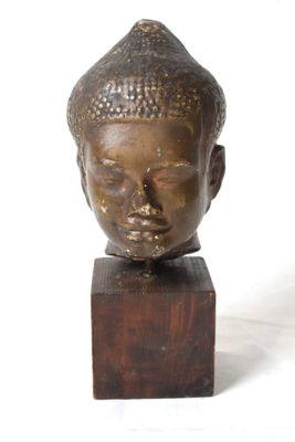 statue of a head on a wooden block on a white background
