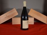 a bottle of wine sitting on a table next to two wooden boxes