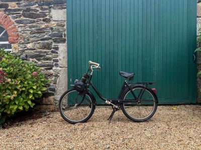 un vélo noir garé devant une porte verte