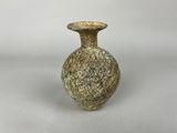 un petit vase posé sur une table