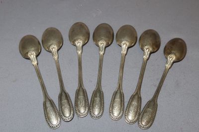six silver spoons sitting on top of a table next to each other