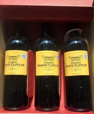 three bottles of wine are in a box on a table