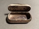 a small silver box that is sitting on a table