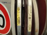 a close up of a parking meter with a sign in the background