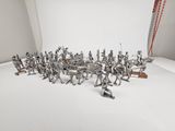 many silver figurines that are on a white surface