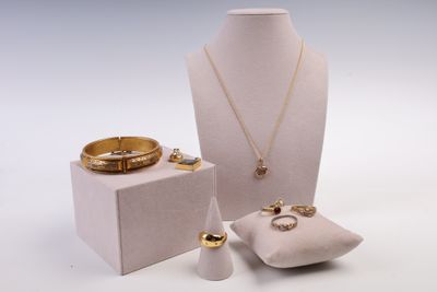 une vitrine blanche contenant une bague, un bracelet, un porte-bague et d'autres bijoux