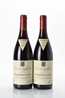 deux bouteilles de vin rouge posées l'une à côté de l'autre sur une surface blanche