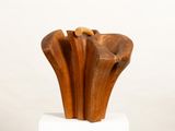 a wooden sculpture of a flower on a white pedestal
