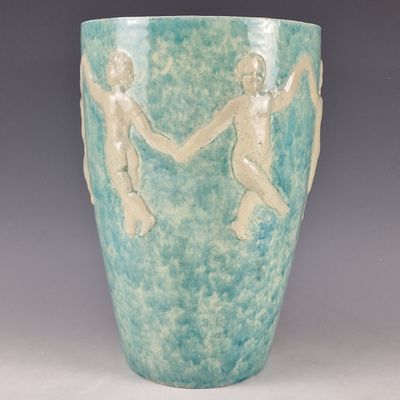 a green vase with two figures on it