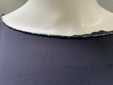 a close up of a woman ' s neck with a necklace made of glass beads