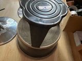 a pan sitting on top of a stove on a wooden floor