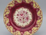 une assiette rouge et jaune ornée d'un motif floral