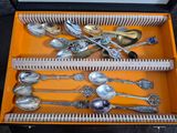 a lot of silver spoons and spoons in a box