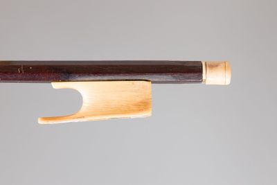 a close up of a violin bow on a gray background