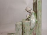 sculpture of a man sitting on a bench reading a book