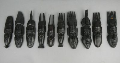 six pièces de bois sculpté sont alignées sur une surface blanche