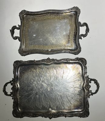 deux plateaux en argent posés l'un à côté de l'autre sur une table