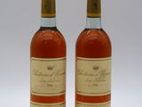 deux bouteilles de vin posées l'une à côté de l'autre sur une surface blanche
