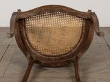 an old chair with a wooden frame and wicker seat