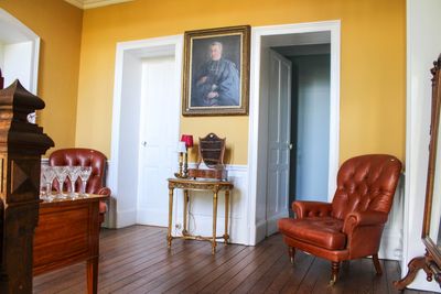 une chaise rouge dans une pièce où se trouve un tableau accroché au mur